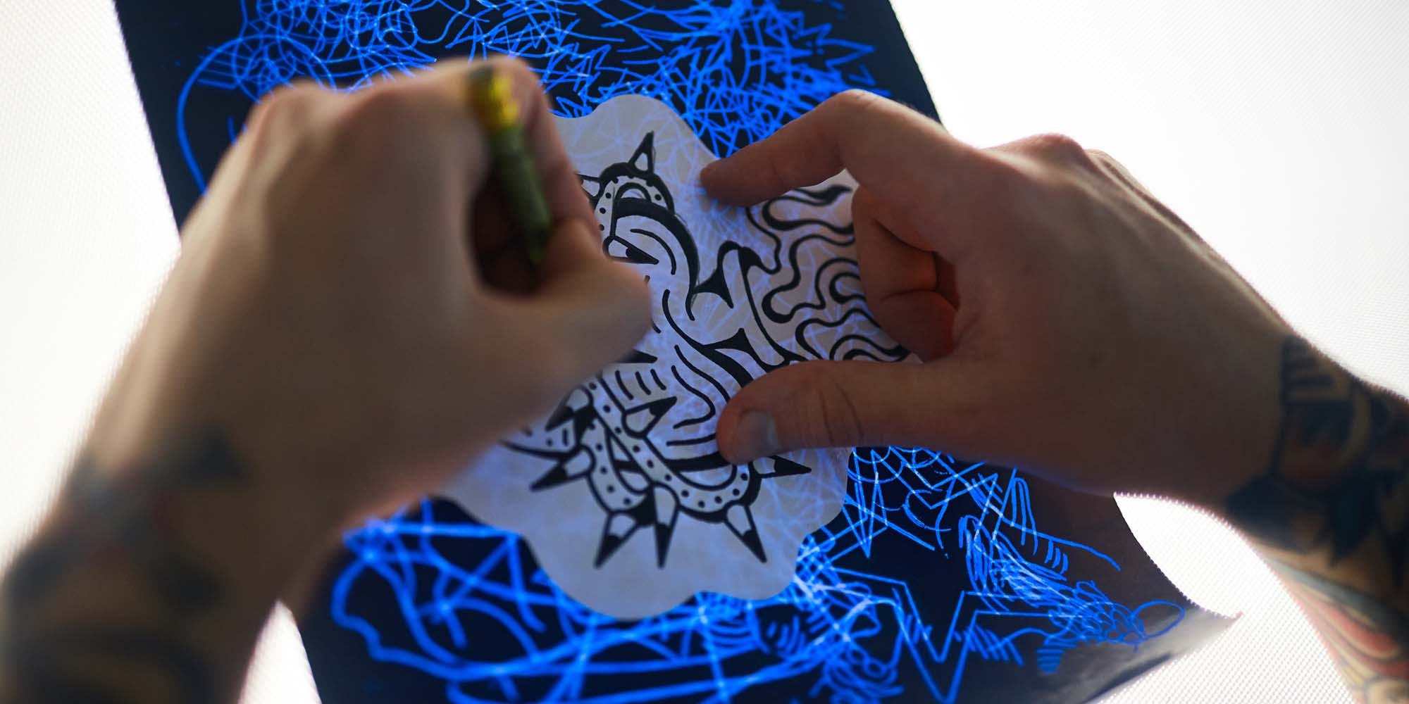 Hands with pencil drawing picture of tattoo adornment